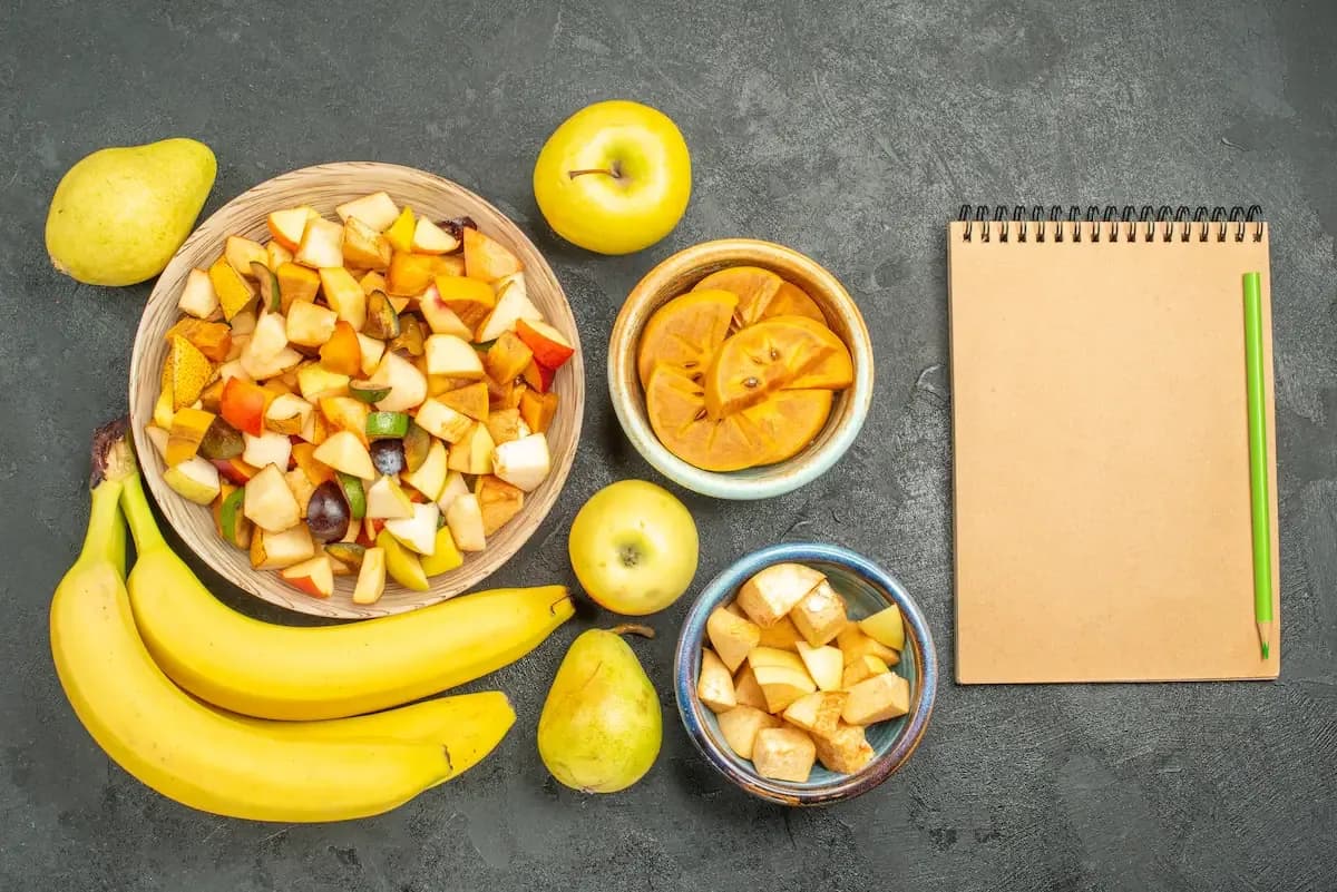 Slices of bananas and apples mixed with some nuts in multiple bowls